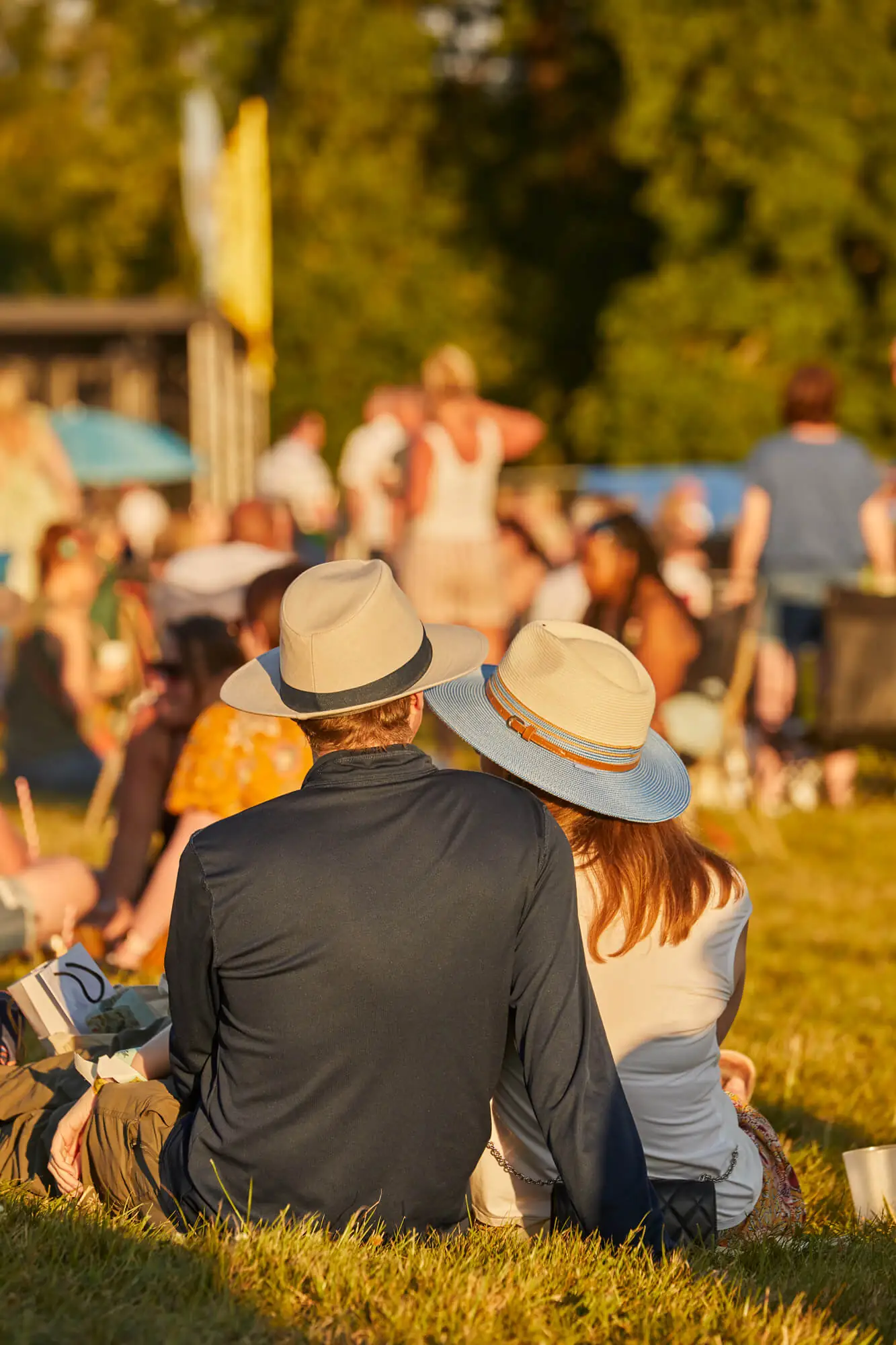 Two adults wearing hats at an event at Borde Hill during the summer.