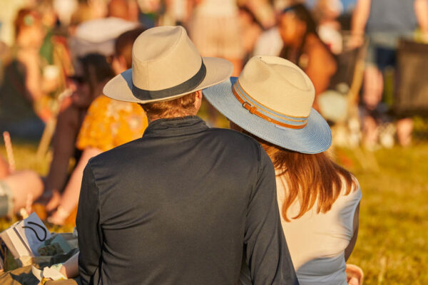Two adults wearing hats at an event at Borde Hill during the summer.